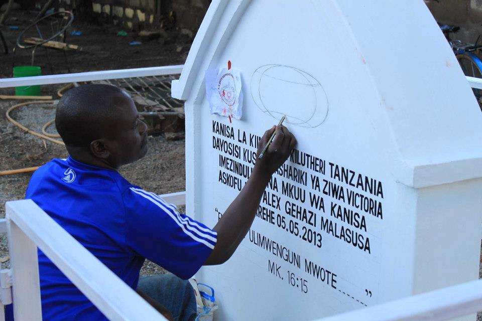 artist preparing the commenorative plaque that will be blessed and mark the beginning of the new diocese